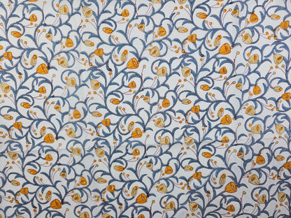 A hand printed floral pattern featuring orange and yellow flowers with blue scrolling vines on a white background.